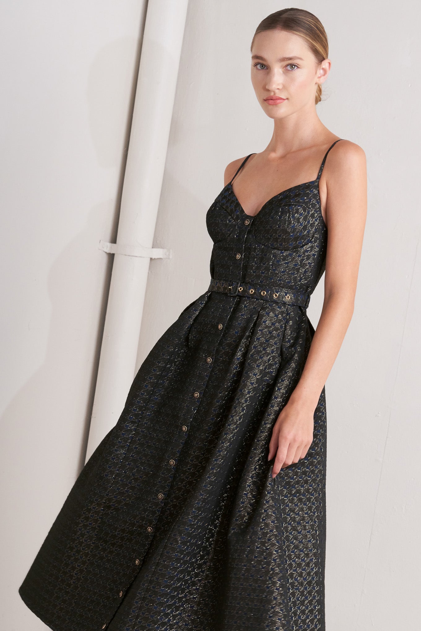 A textured woven midi dress featuring cami top with straps, self belt, full skirt and front button down closure