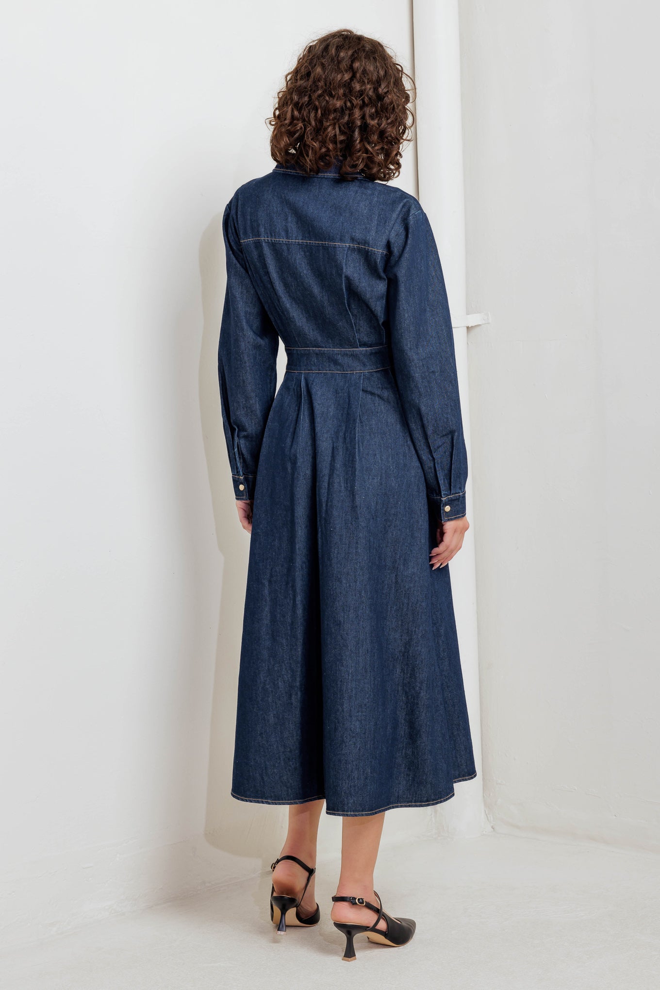 A denim midi dress featuring collar, front snap button closure, long sleeve, wide waist band and full skirt