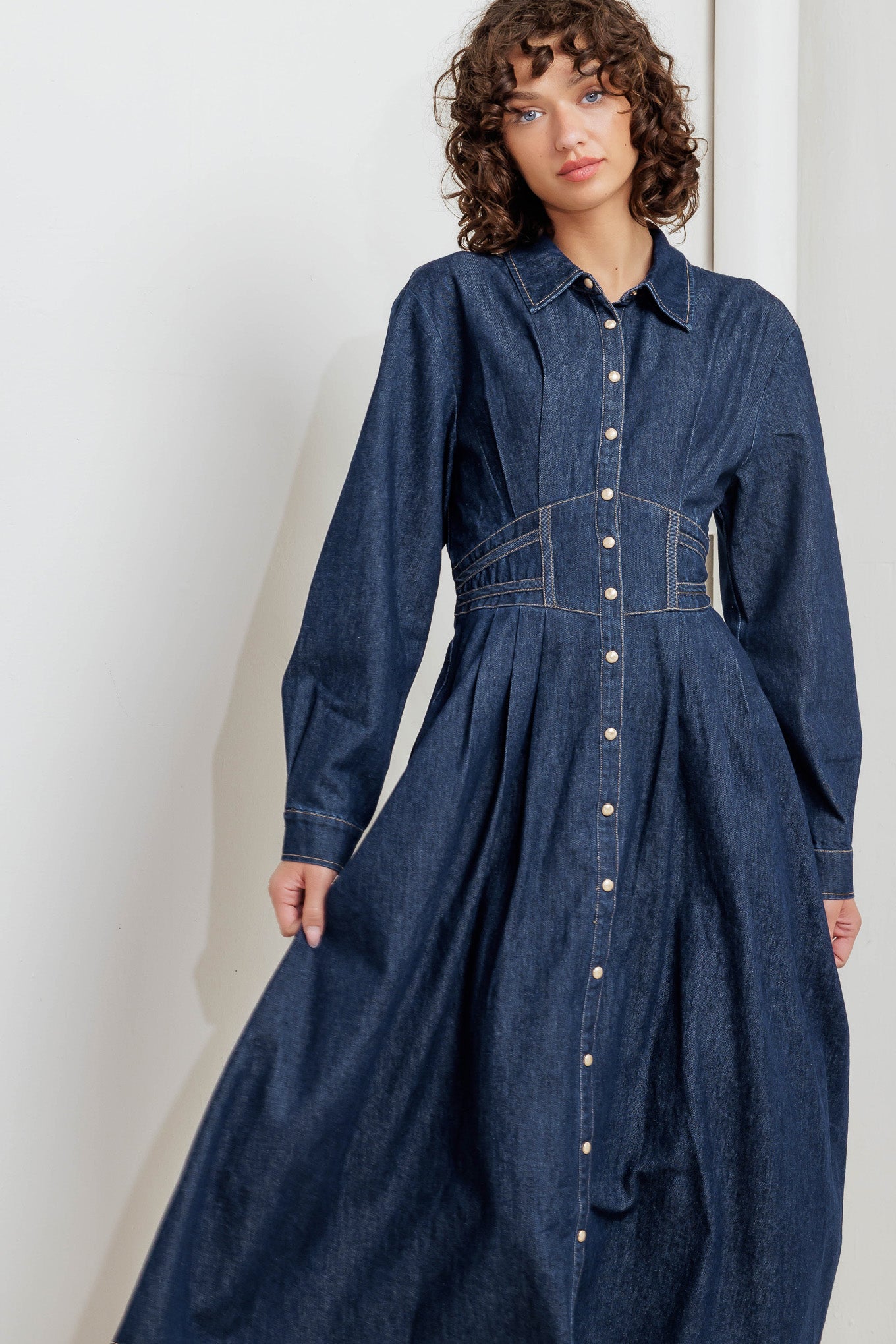 A denim midi dress featuring collar, front snap button closure, long sleeve, wide waist band and full skirt