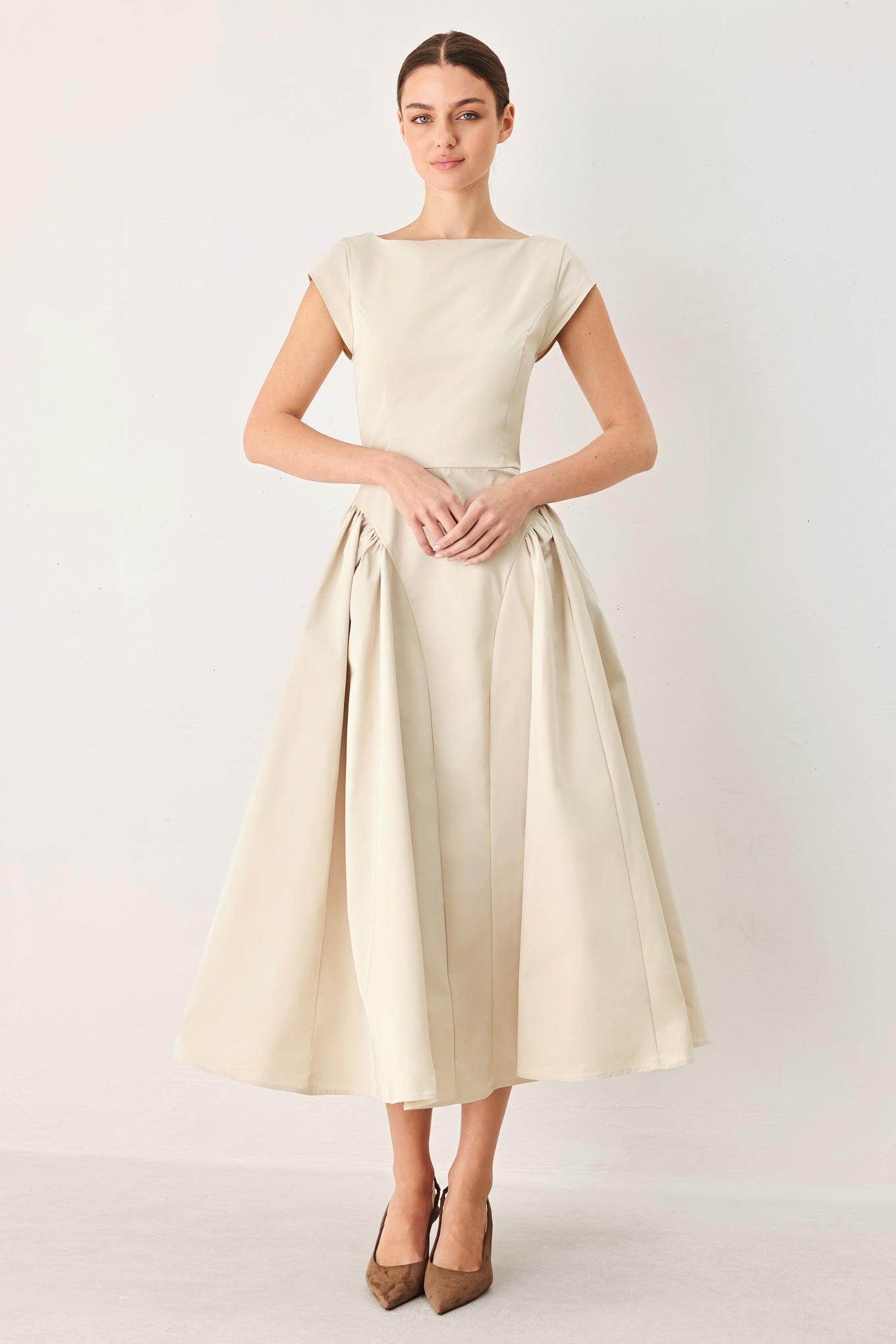 Woman wearing a solid light taupe woven midi dress featuring wide neckline, cap sleeve, side shirred full skirt, back cut out and button zipper closure | FREEMARKET