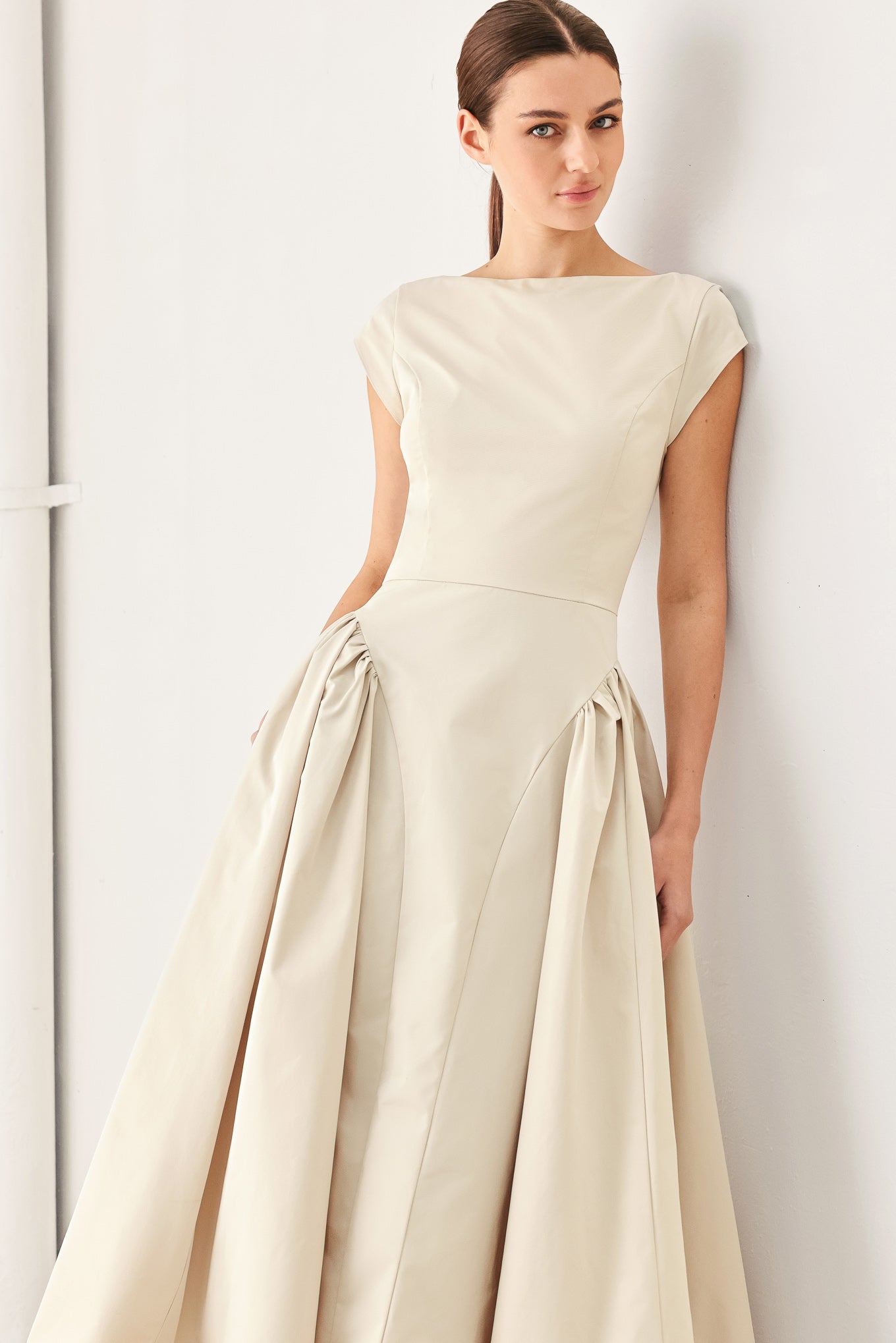 Woman wearing a solid light taupe woven midi dress featuring wide neckline, cap sleeve, side shirred full skirt, back cut out and button zipper closure | FREEMARKET