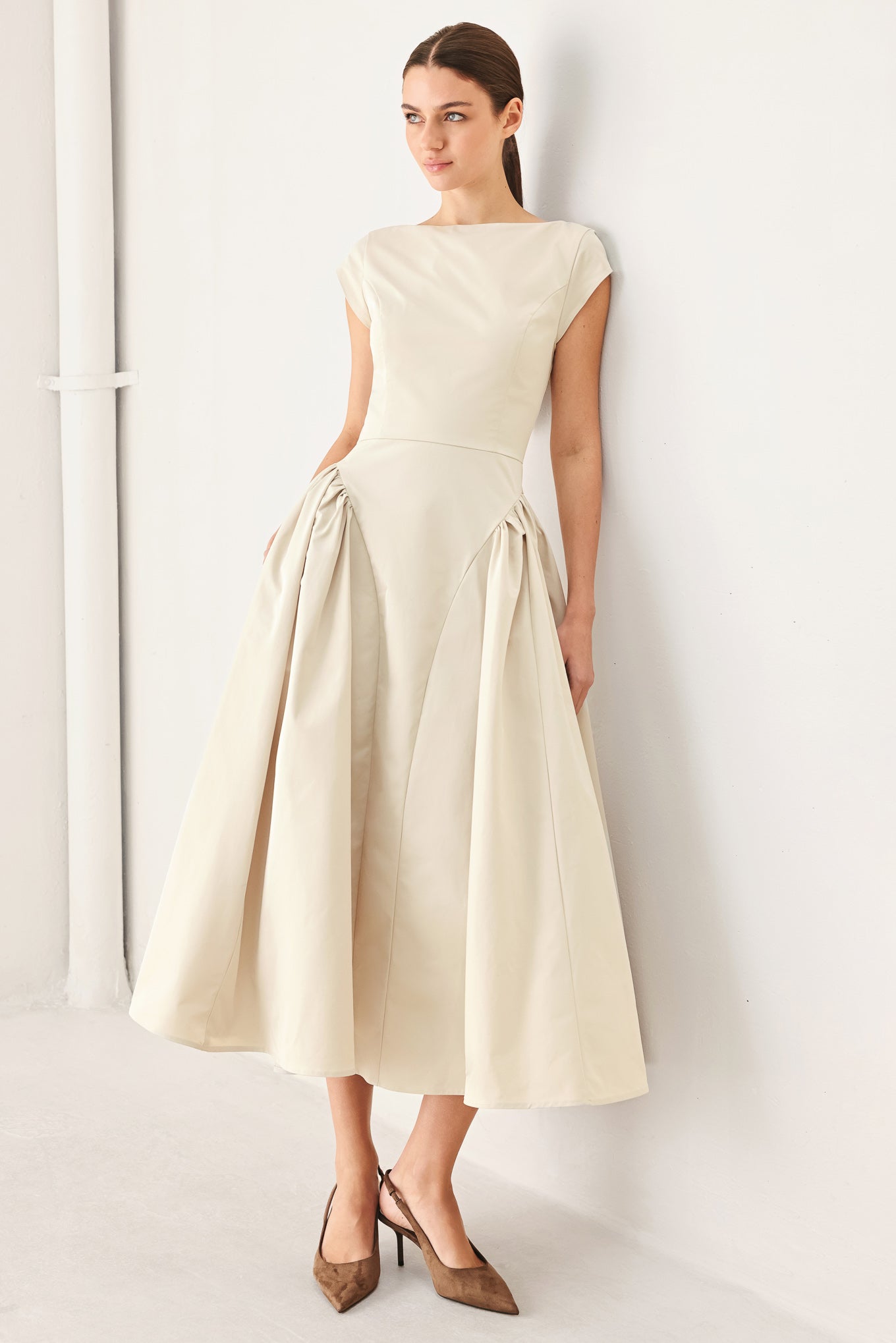 Woman wearing a solid light taupe woven midi dress featuring wide neckline, cap sleeve, side shirred full skirt, back cut out and button zipper closure | FREEMARKET
