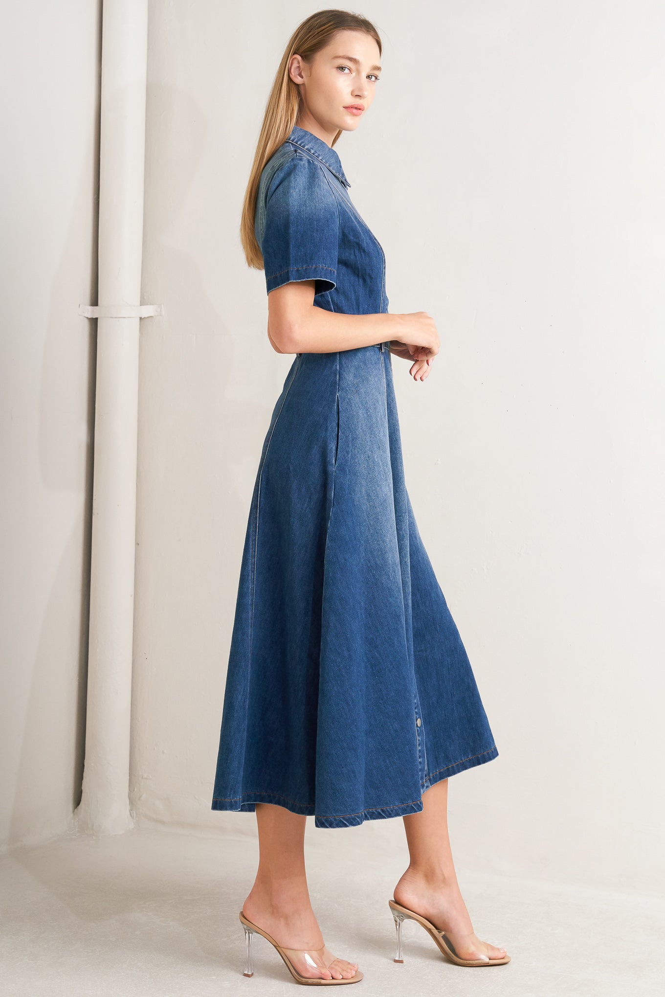 A washed denim midi dress featuring collar, snap button down, short sleeve and circle skirt