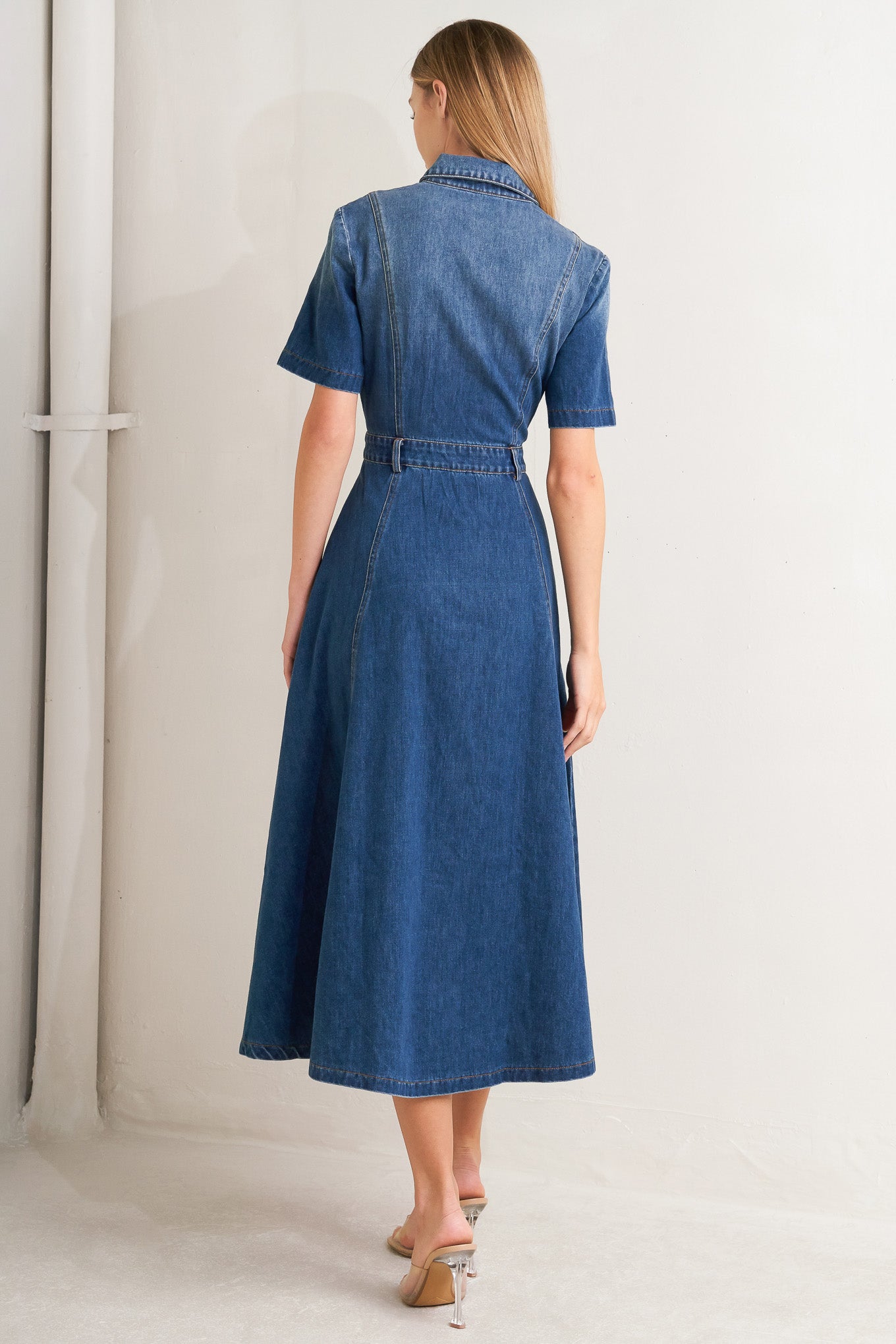 A washed denim midi dress featuring collar, snap button down, short sleeve and circle skirt