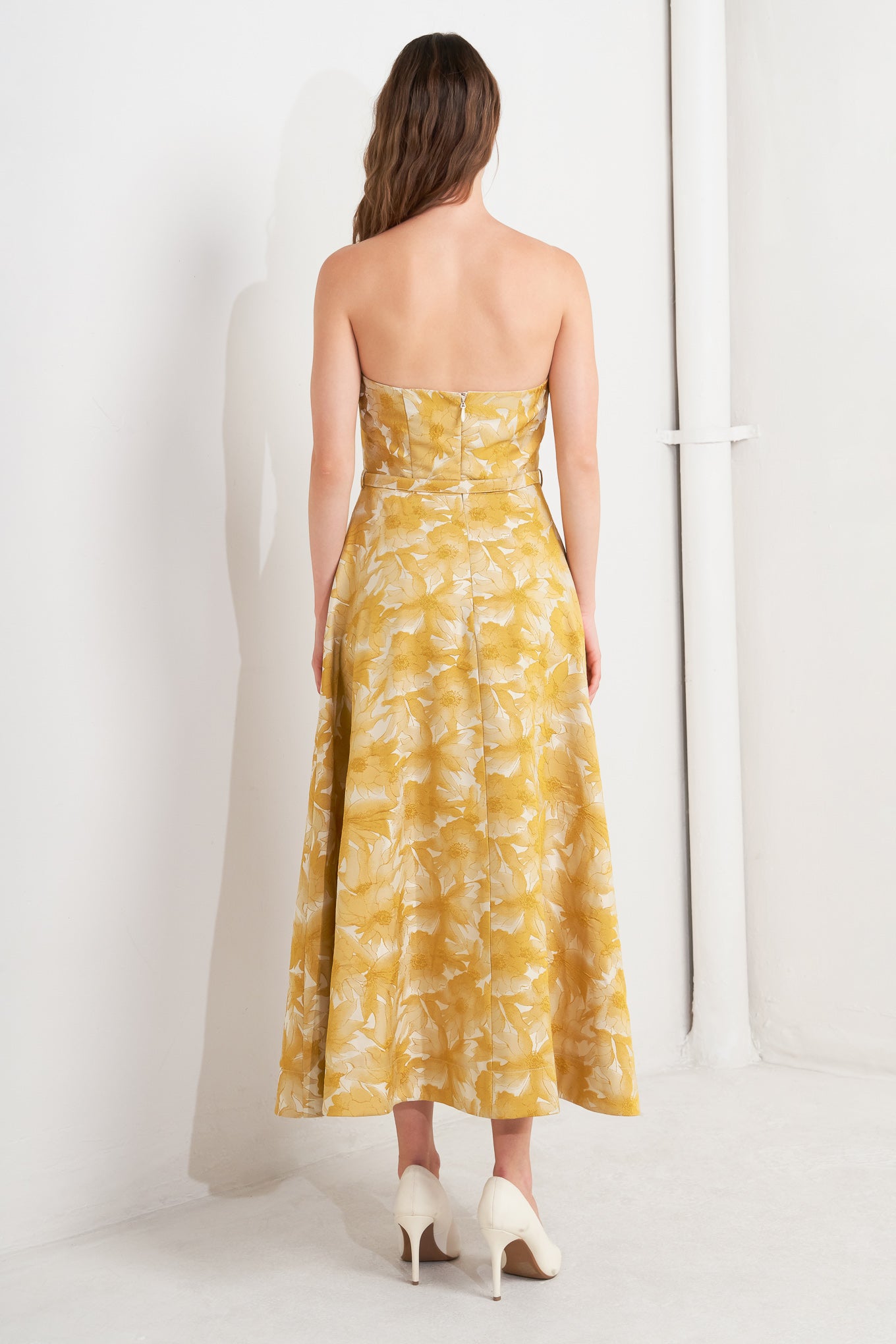 A woven jacquard midi dress featuring strapless, self belt, circle skirt and back zipper closure