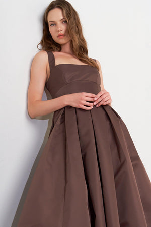 A solid woven midi dress featuring straight neckline, straps, full skirt, low back and zipper closure