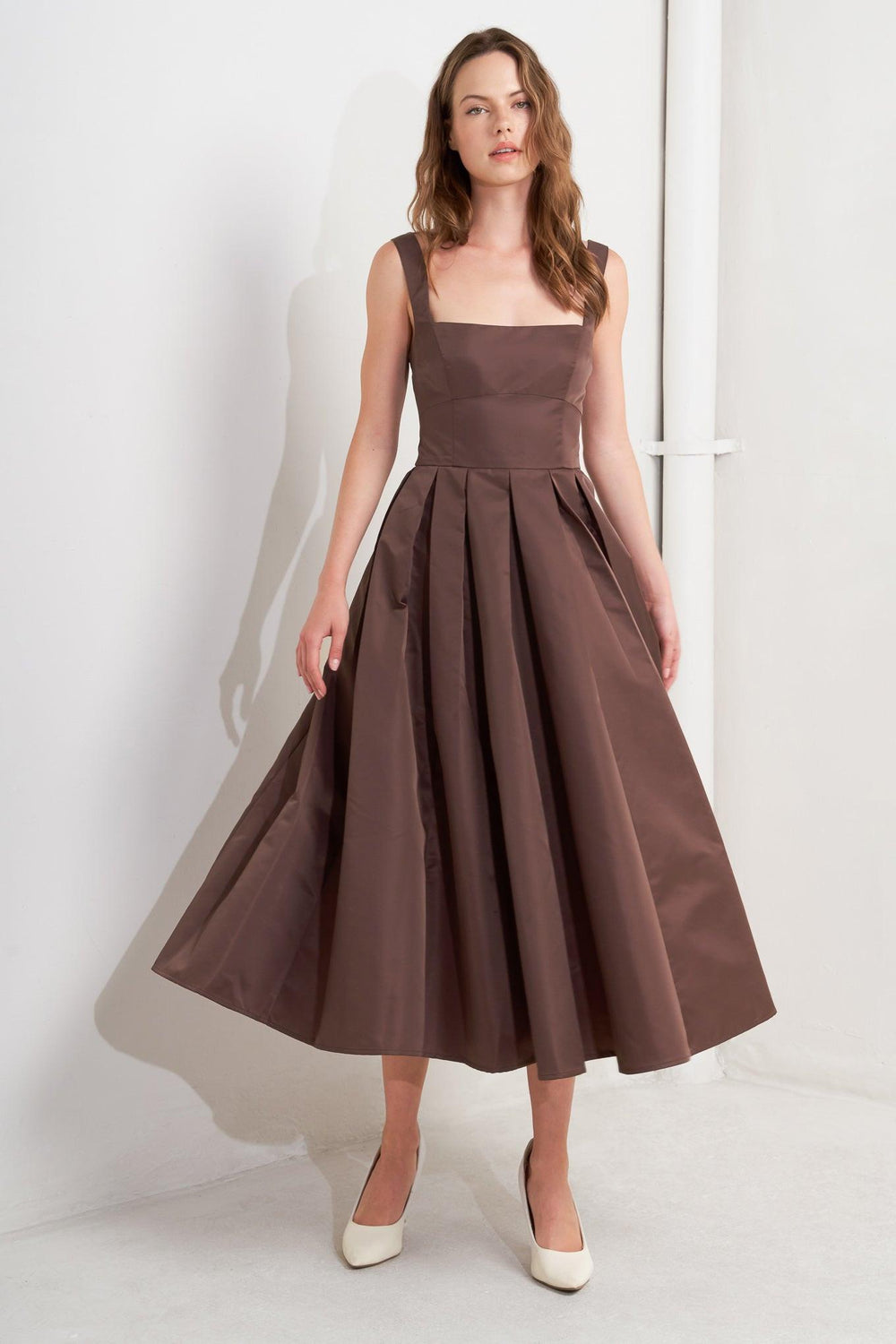 A solid woven midi dress featuring straight neckline, straps, full skirt, low back and zipper closure