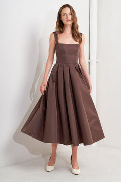 A solid woven midi dress featuring straight neckline, straps, full skirt, low back and zipper closure