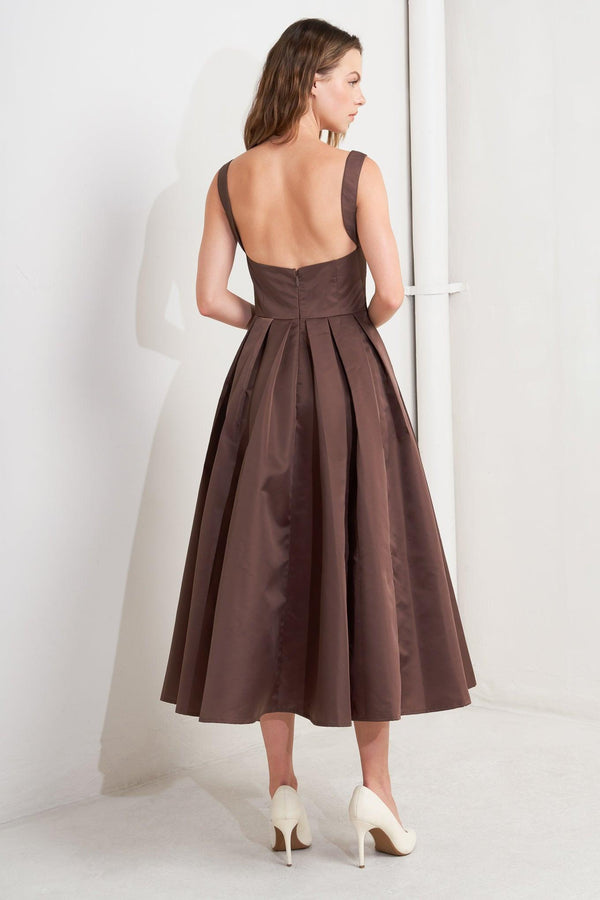 A solid woven midi dress featuring straight neckline, straps, full skirt, low back and zipper closure