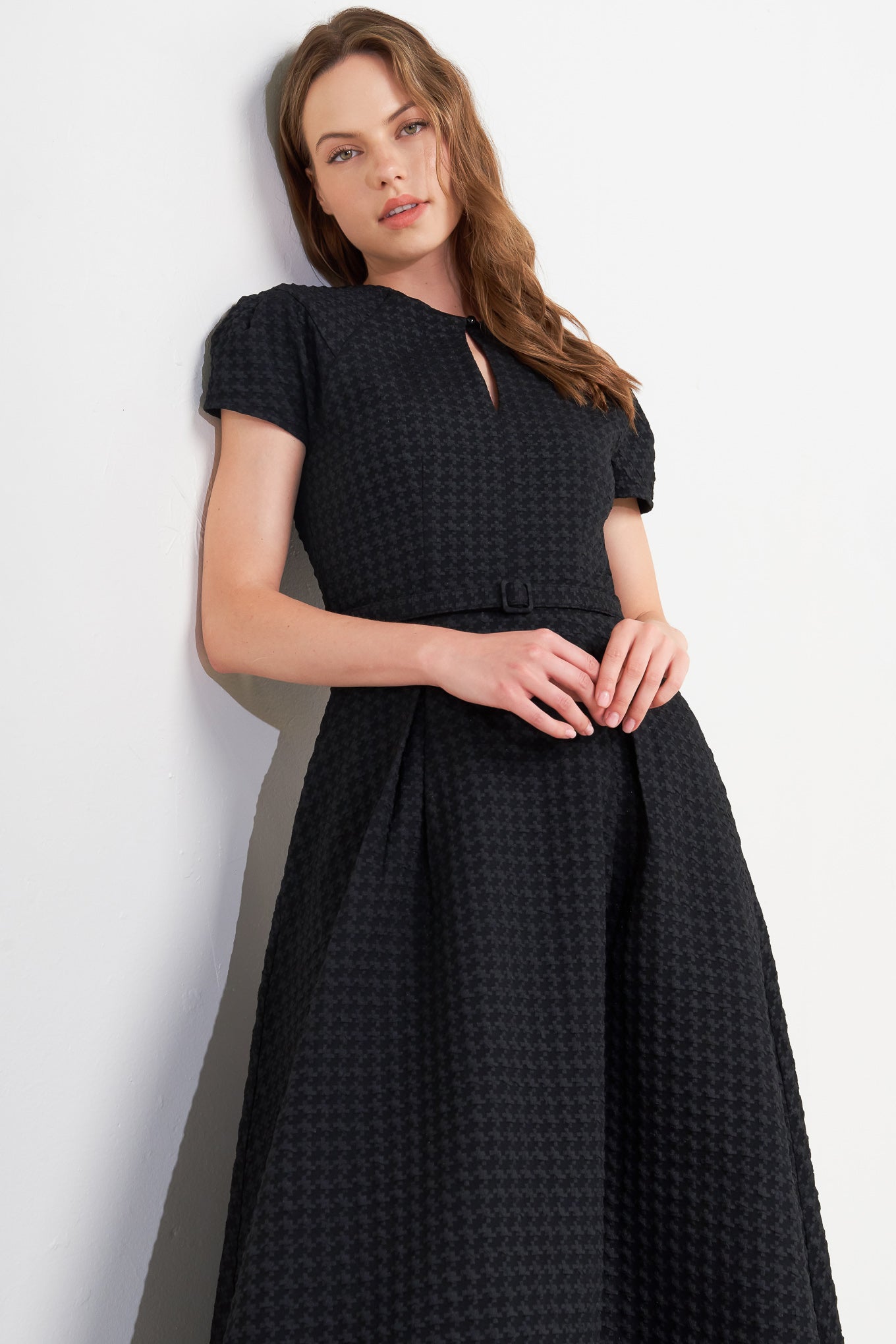 A textured woven midi dress featuring round neckline, center front button with cut out, short sleeve, full skirt, self belt and back zipper closure