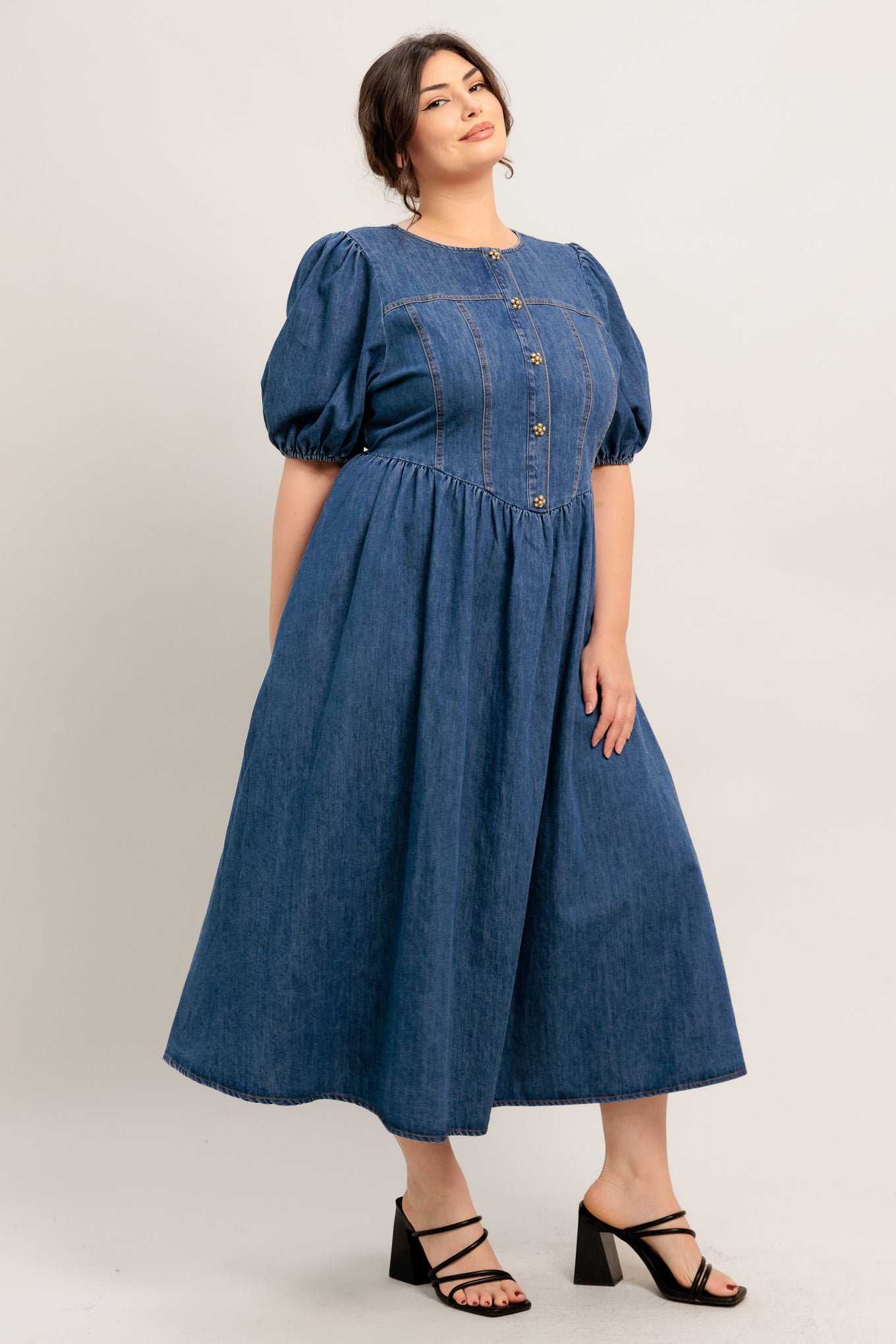 
A washed denim midi dress featuring round neckline, short puff sleeve, jewel button down, side shirring detail. full skirt and back zipper closure

Details:

Self : 85% Cotton 15% Polyester

Size &amp; Fit

- Model is 5`8" And Wearing Size Small
- Measurements Taken From Size Small
- Approx. Length: 50"