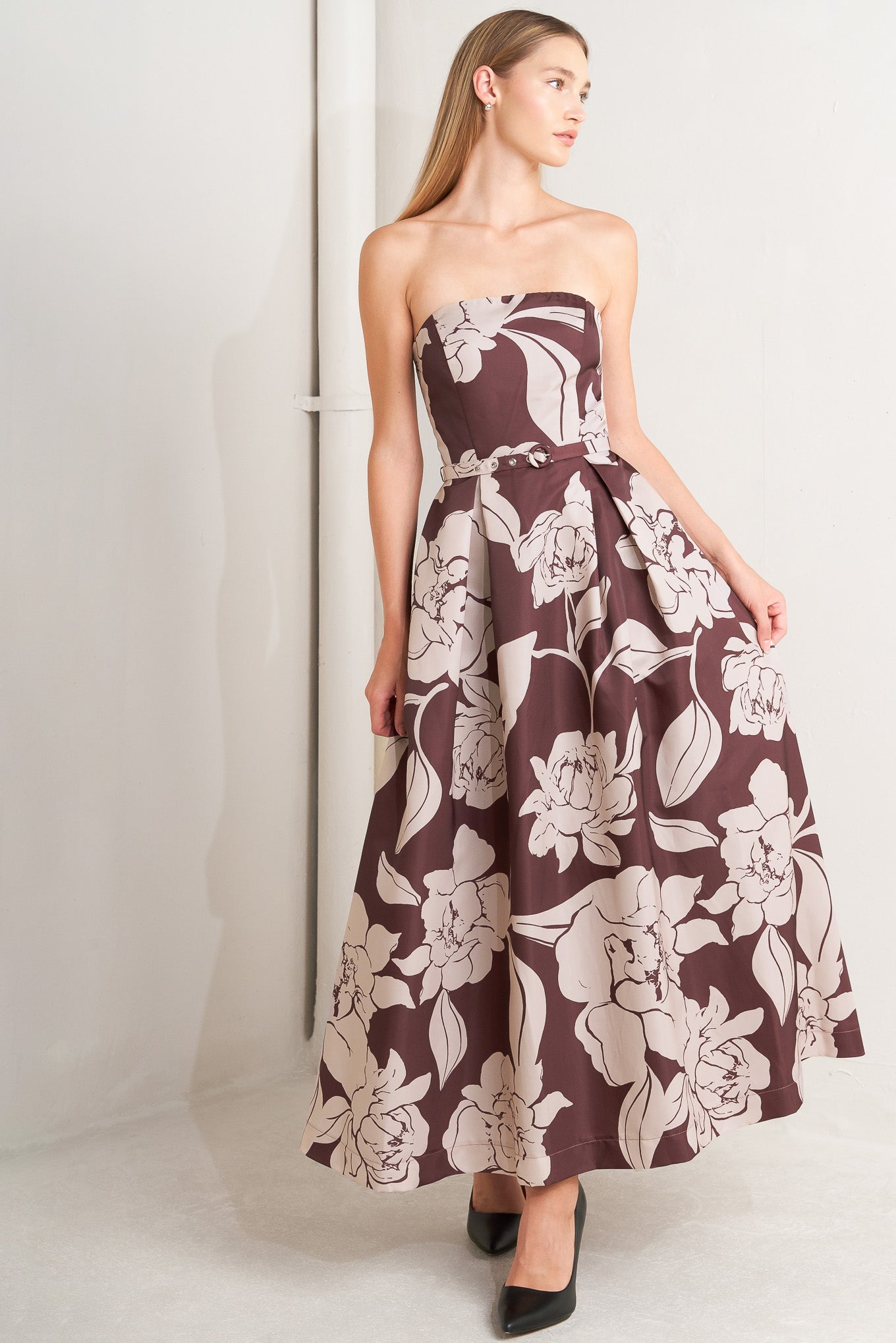 A printed woven midi dress featuring strapless, self belt, full skirt and back zipper closure