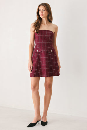 A woman modeling a strapless tube dress in a deep wine burgundy red plaid tweed fabric with white windowpane lines and two decorative buttons on the front | FREEMARKET