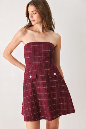 A woman modeling a strapless tube dress in a deep wine burgundy red plaid tweed fabric with white windowpane lines and two decorative buttons on the front | FREEMARKET
