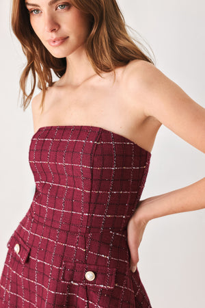 A woman modeling a strapless tube dress in a deep wine burgundy red plaid tweed fabric with white windowpane lines and two decorative buttons on the front | FREEMARKET