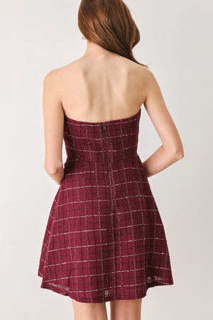 A woman modeling a strapless tube dress in a deep wine burgundy red plaid tweed fabric with white windowpane lines and two decorative buttons on the front | FREEMARKET