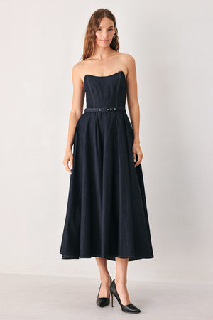 A woman wearing a strapless midi dress in dark navy blue with a matching belt | FREEMARKET