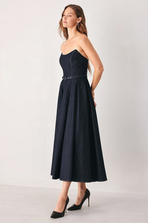 A woman wearing a strapless midi dress in dark navy blue with a matching belt | FREEMARKET