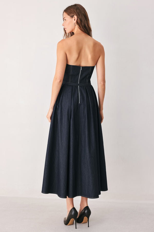 A woman wearing a strapless midi dress in dark navy blue with a matching belt | FREEMARKET