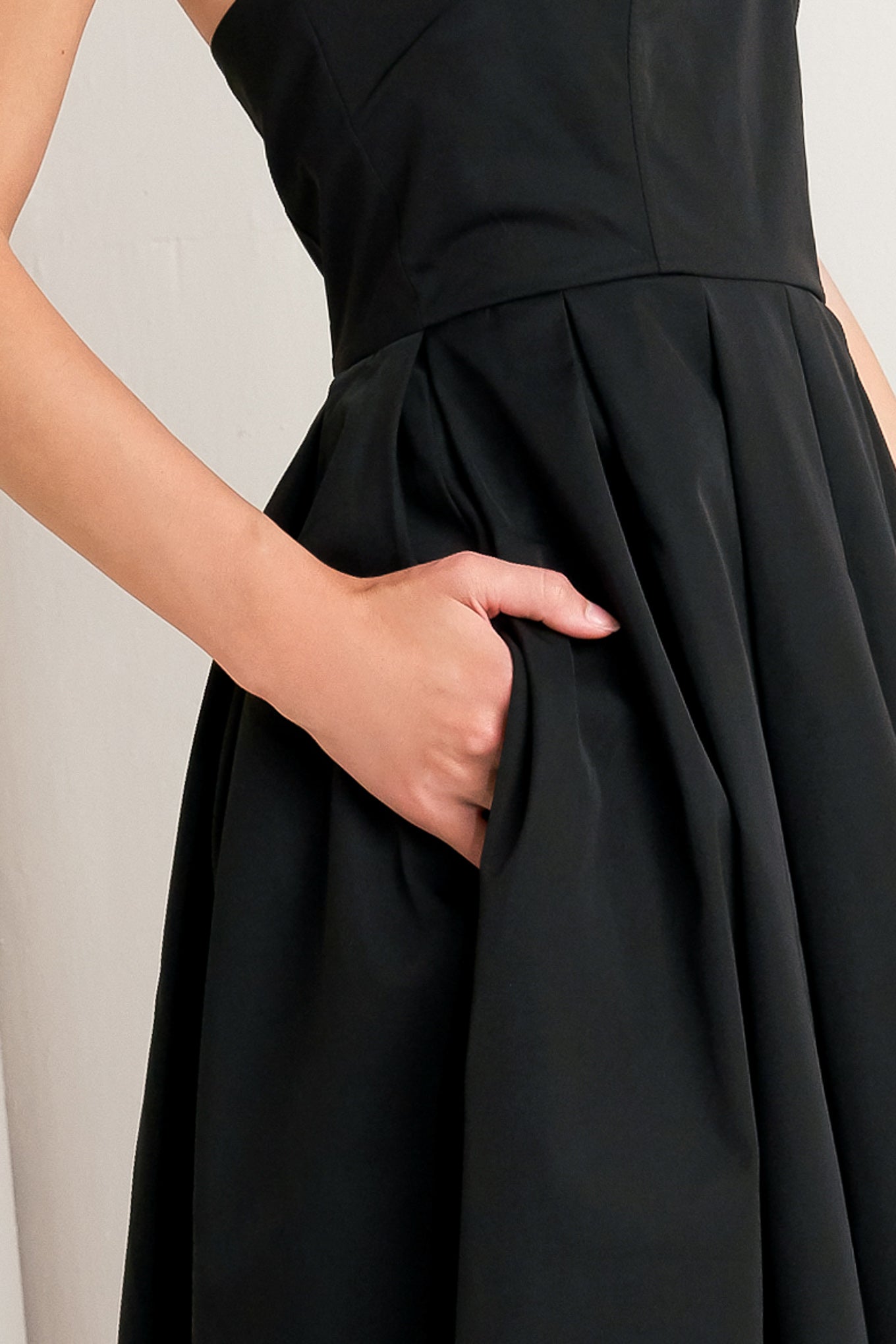 A solid woven midi dress featuring strapless with pointed side neckline, full skirt and back zipper closure