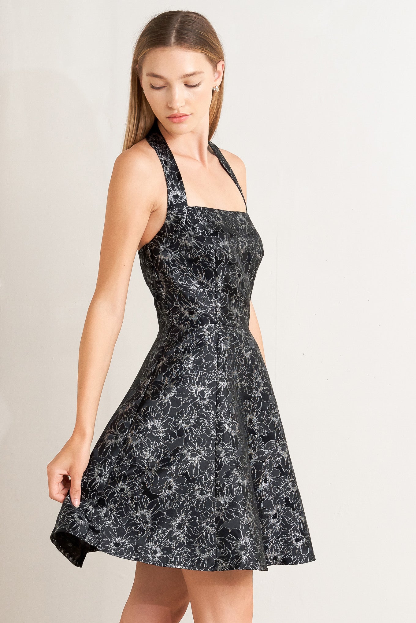 A woven jacquard mini dress featuring halter neckline, circle skirt open back with button and zipper closure