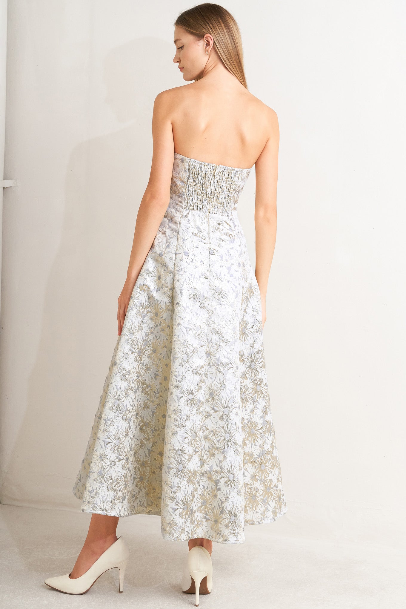 A woven jacquard woven midi dress featuring strapless neckline, circle skirt and smocked back with zipper closure
