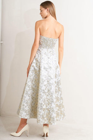 A woven jacquard woven midi dress featuring strapless neckline, circle skirt and smocked back with zipper closure