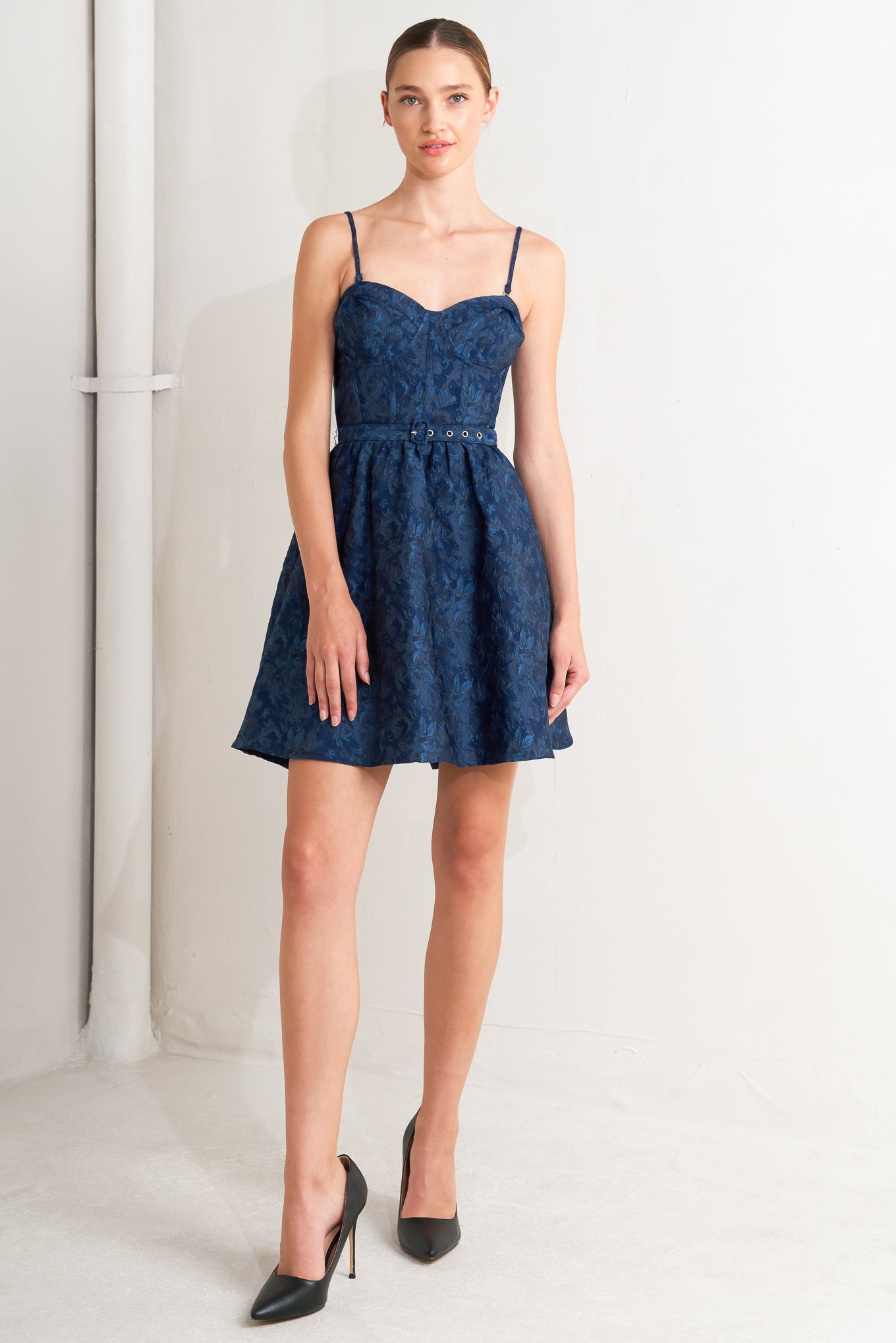 A woven jacquard mini dress featuring bustier top, straps, self belt, full skirt and back zipper closure