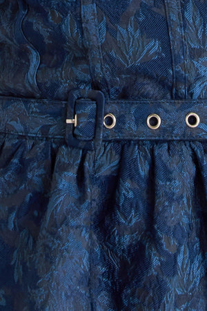 A woven jacquard mini dress featuring bustier top, straps, self belt, full skirt and back zipper closure