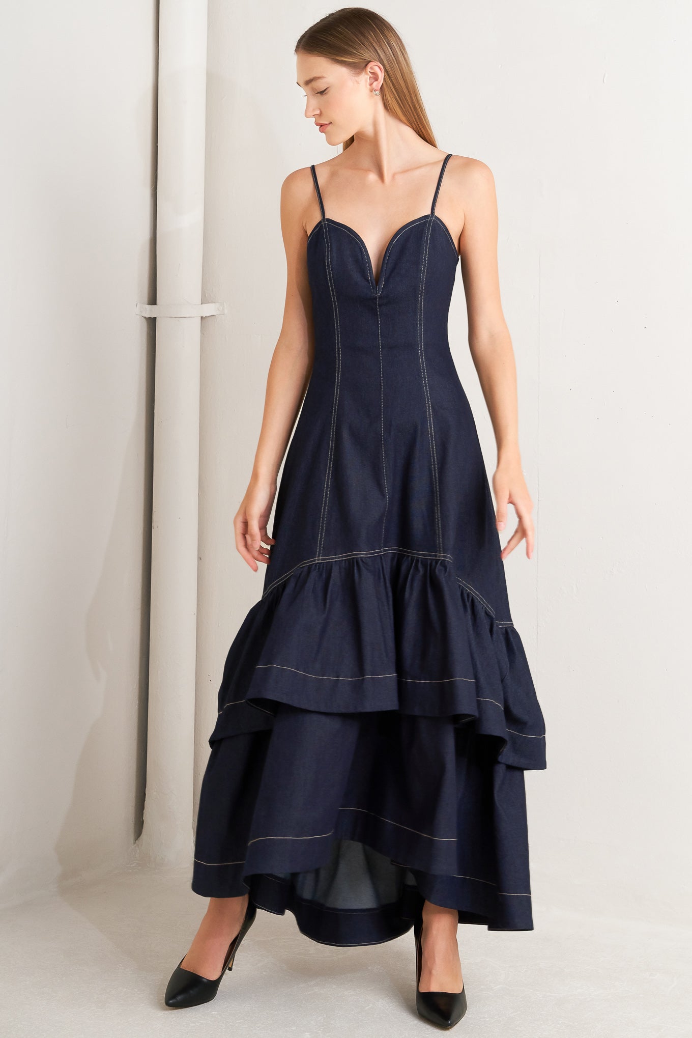 A denim midi dress featuring sweetheart neckline, straps, double layer ruffled bottom and back zipper closure