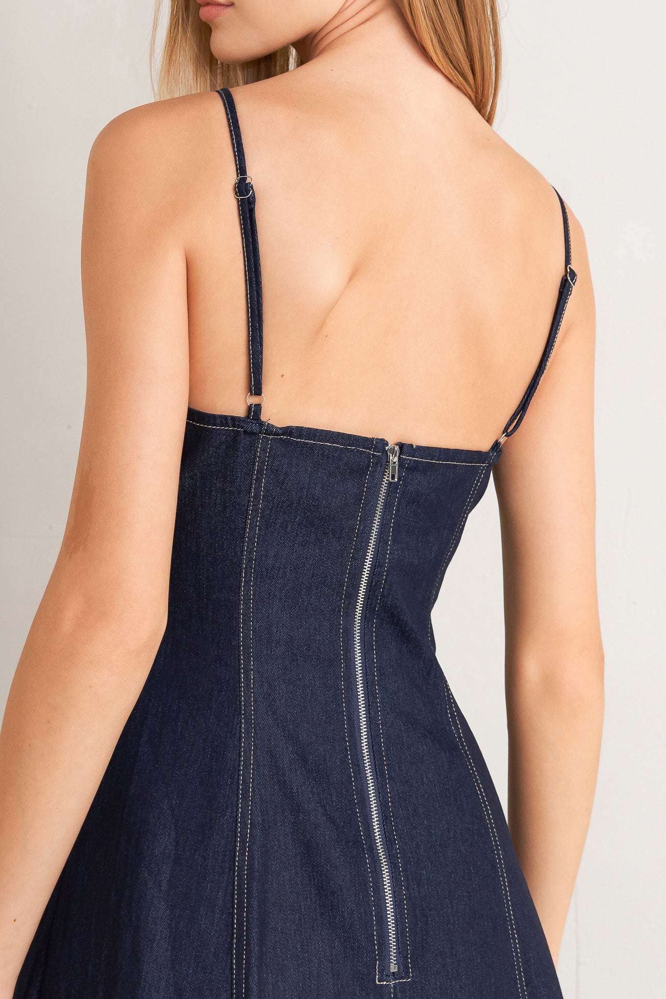 A denim midi dress featuring sweetheart neckline, straps, double layer ruffled bottom and back zipper closure