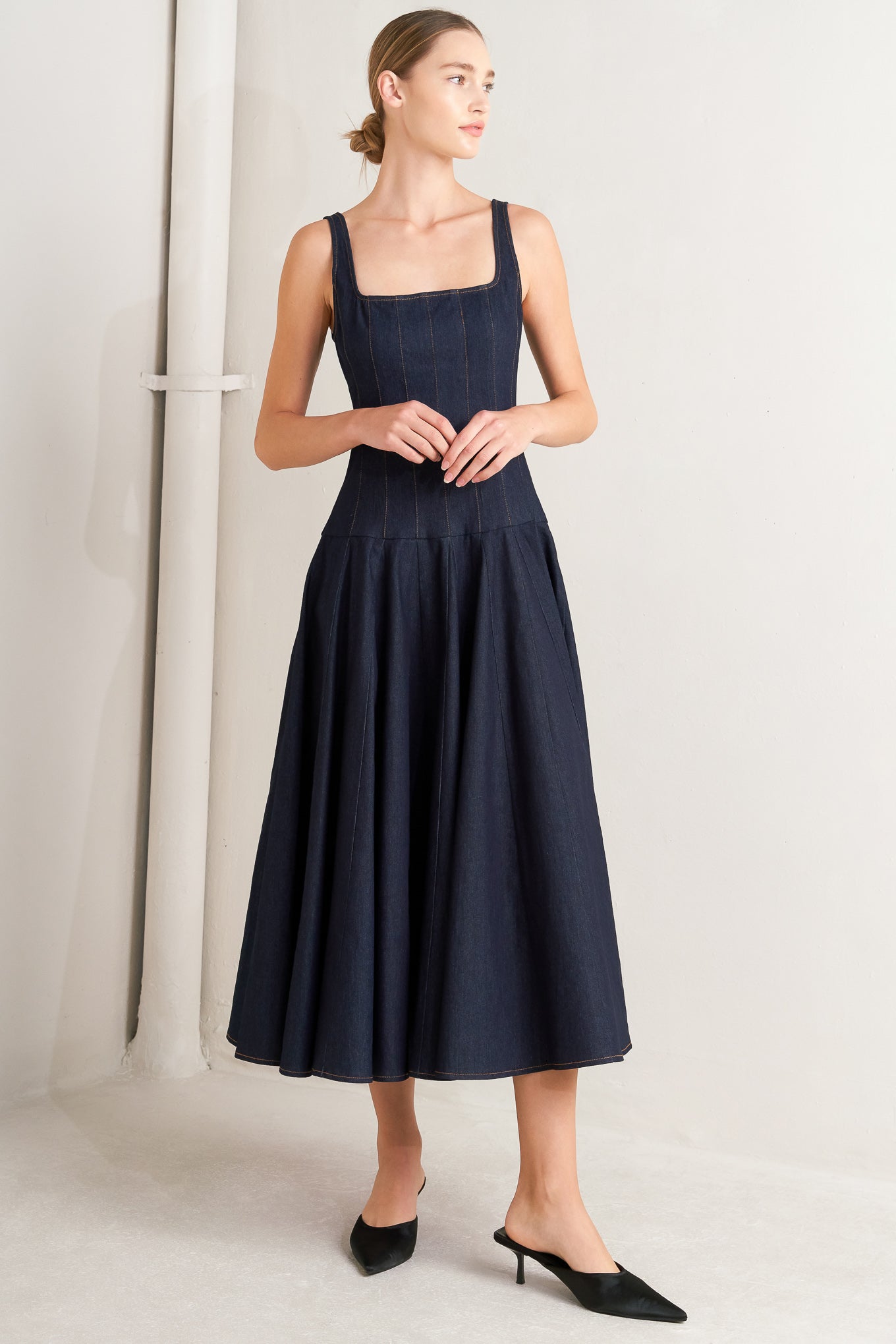 A denim midi dress featuring square neckline, sleeveless, dropped waistline, circle skirt and back zipper closure