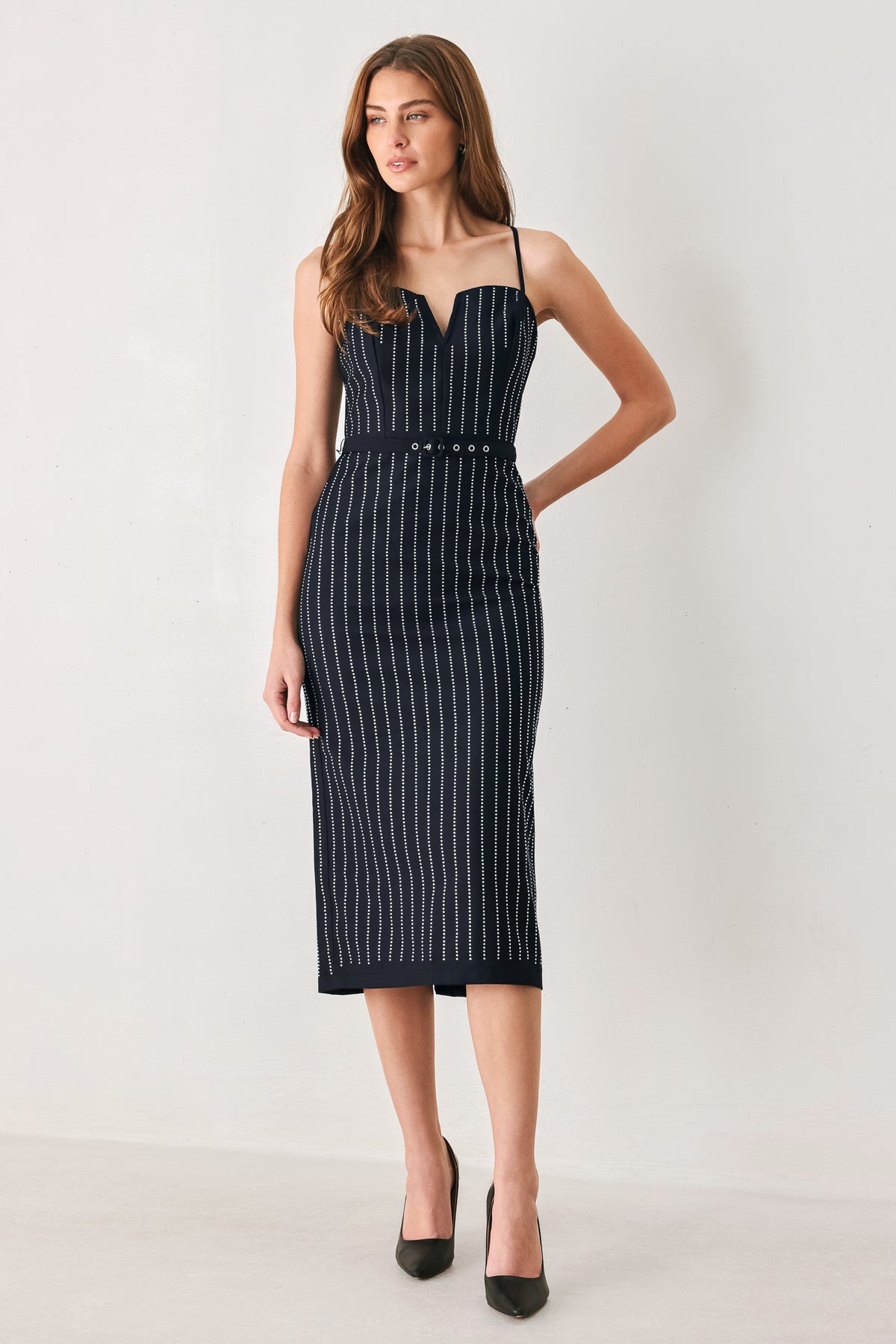 A woman modeling a sleeveless navy midi dress with thin white vertical rhinestone pinstripes, a sweetheart neckline, and a matching navy belt with silver-tone studs | FREEMARKET