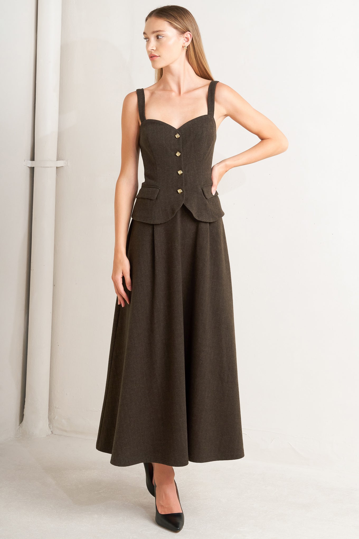 A solid woven midi dress featuring sweetheart neckline, straps, front button detail, circle skirt and back zipper closure