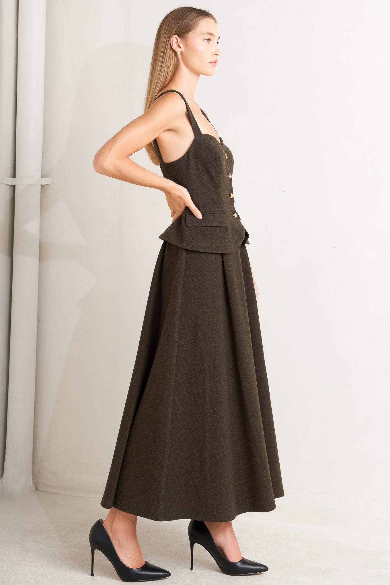 A solid woven midi dress featuring sweetheart neckline, straps, front button detail, circle skirt and back zipper closure