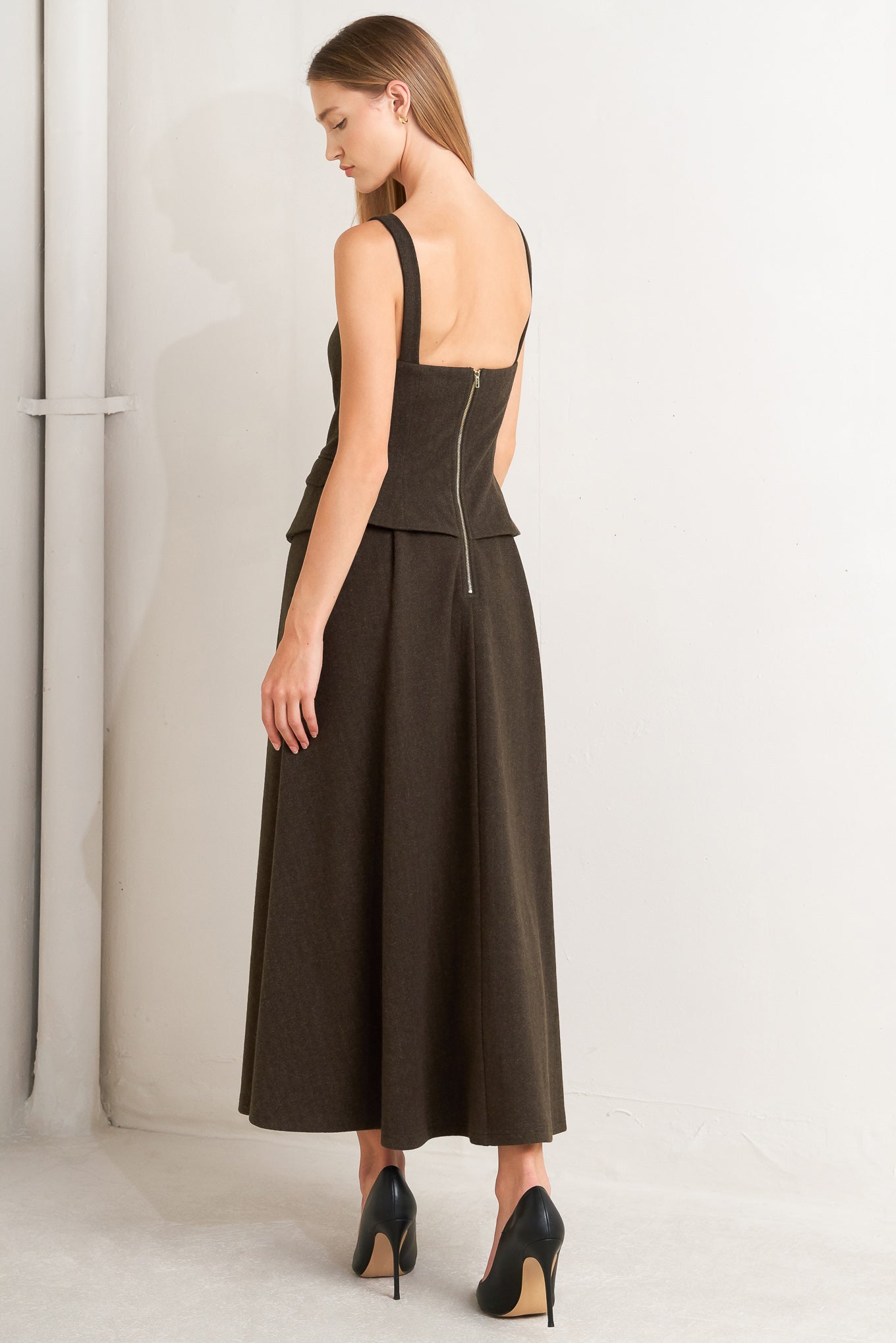 A solid woven midi dress featuring sweetheart neckline, straps, front button detail, circle skirt and back zipper closure
