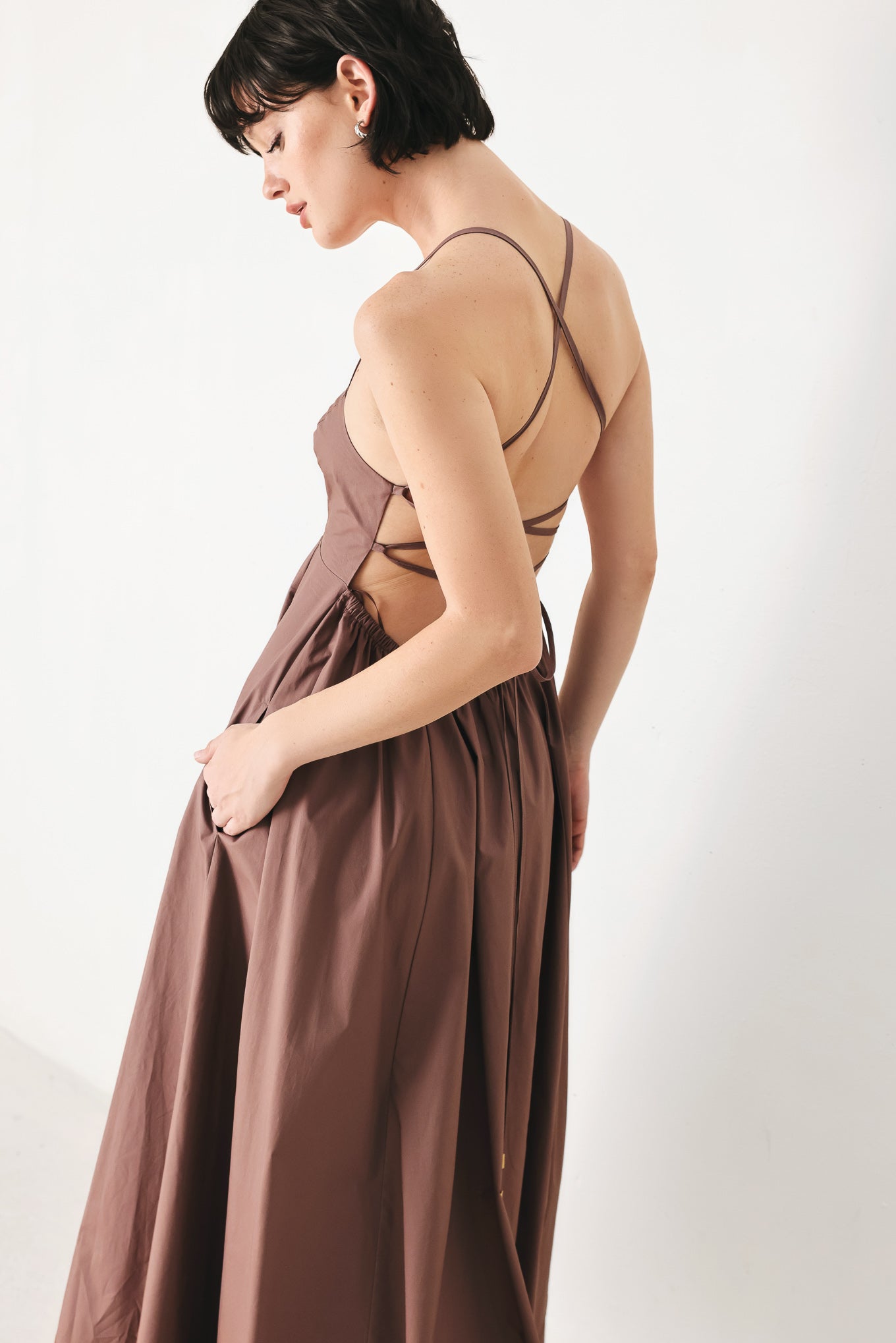 Woman wearing a brown midi dress featuring straight neckline, circle skirt and bare back with lace up tie closure | FREEMARKET | Flying Tomato