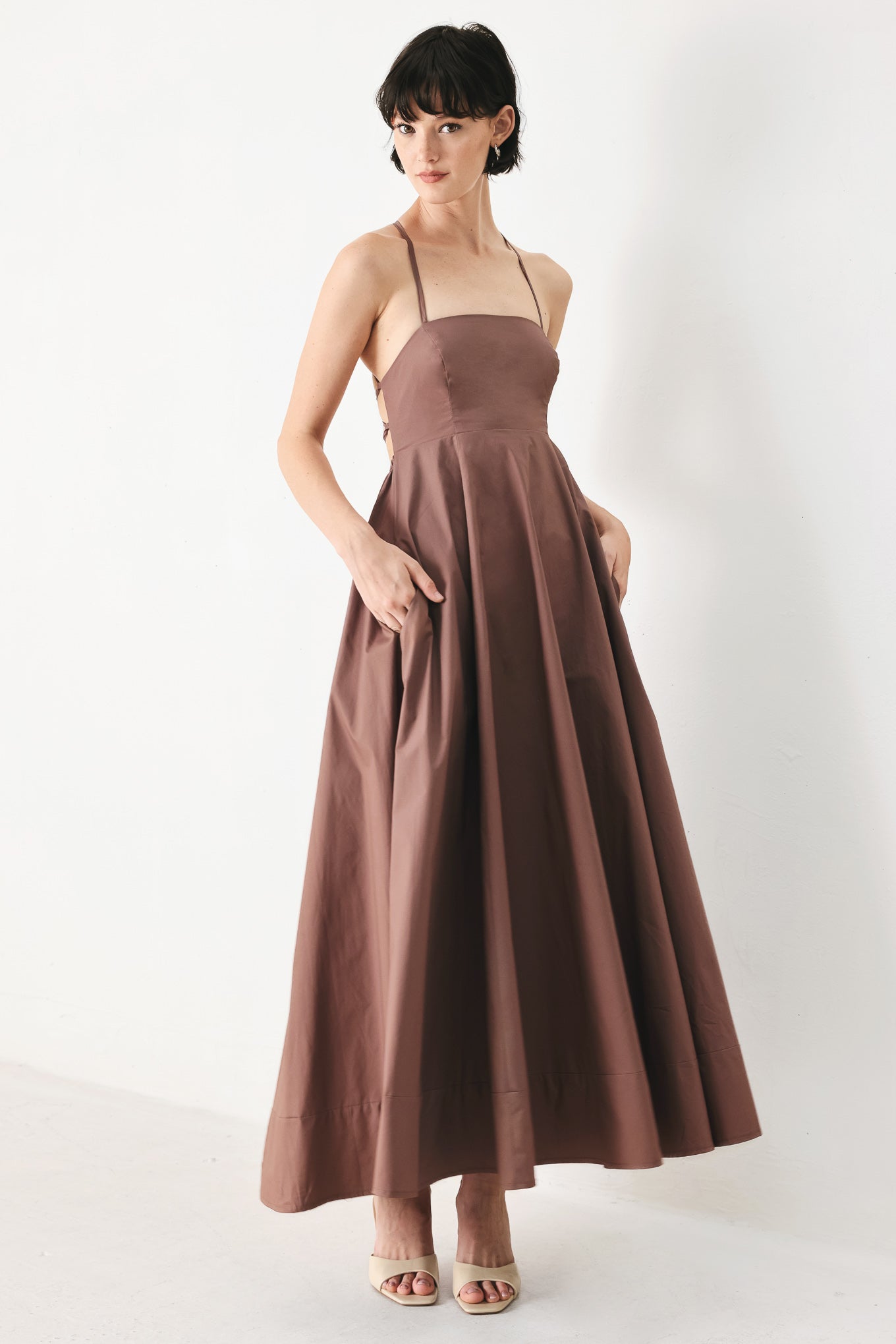 Woman wearing a brown midi dress featuring straight neckline, circle skirt and bare back with lace up tie closure | FREEMARKET | Flying Tomato