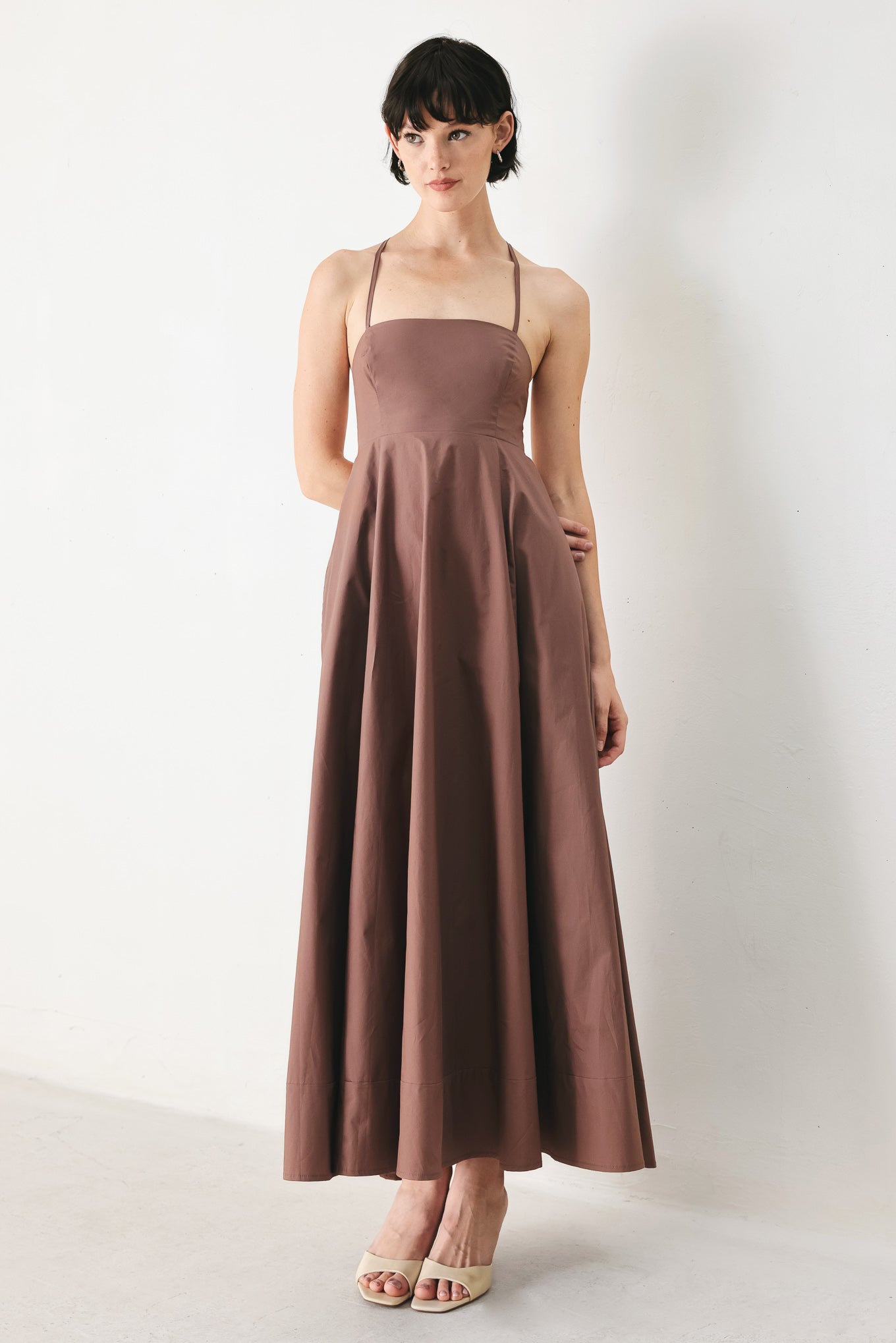 Woman wearing a brown midi dress featuring straight neckline, circle skirt and bare back with lace up tie closure | FREEMARKET | Flying Tomato