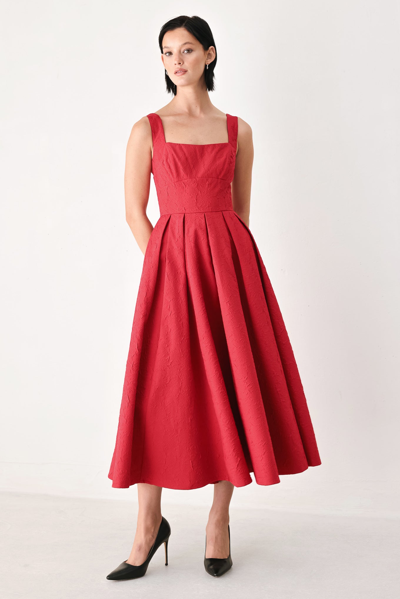 A woman modeling a sleeveless red midi dress with a square neckline, structured bodice, and full pleated skirt | FREEMARKET