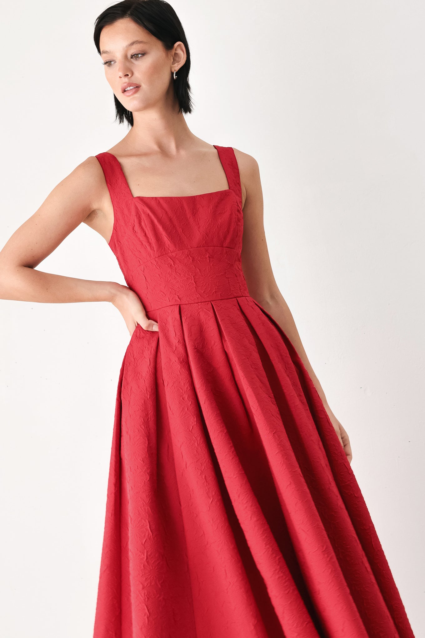 A woman modeling a sleeveless red midi dress with a square neckline, structured bodice, and full pleated skirt | FREEMARKET