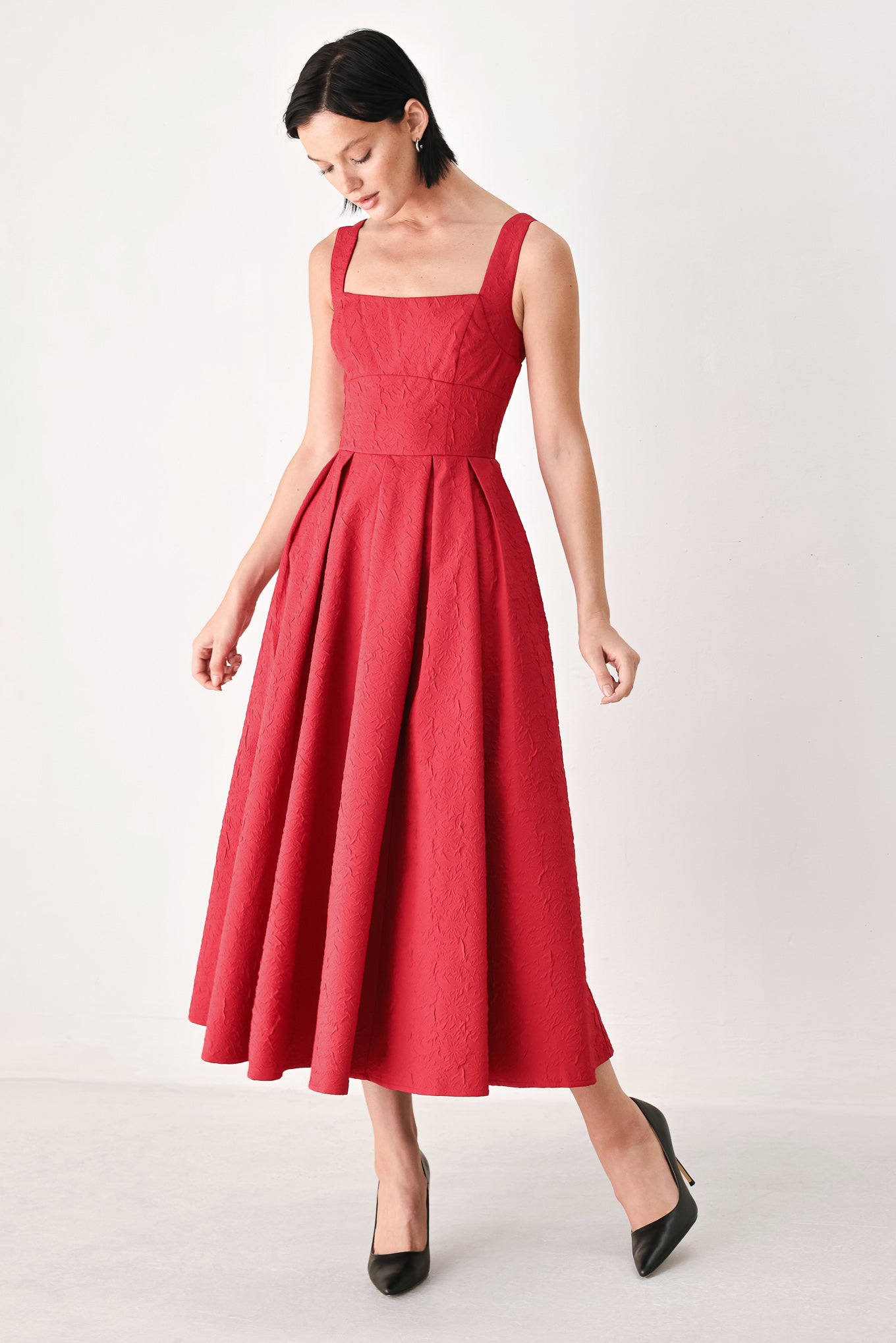 A woman modeling a sleeveless red midi dress with a square neckline, structured bodice, and full pleated skirt | FREEMARKET