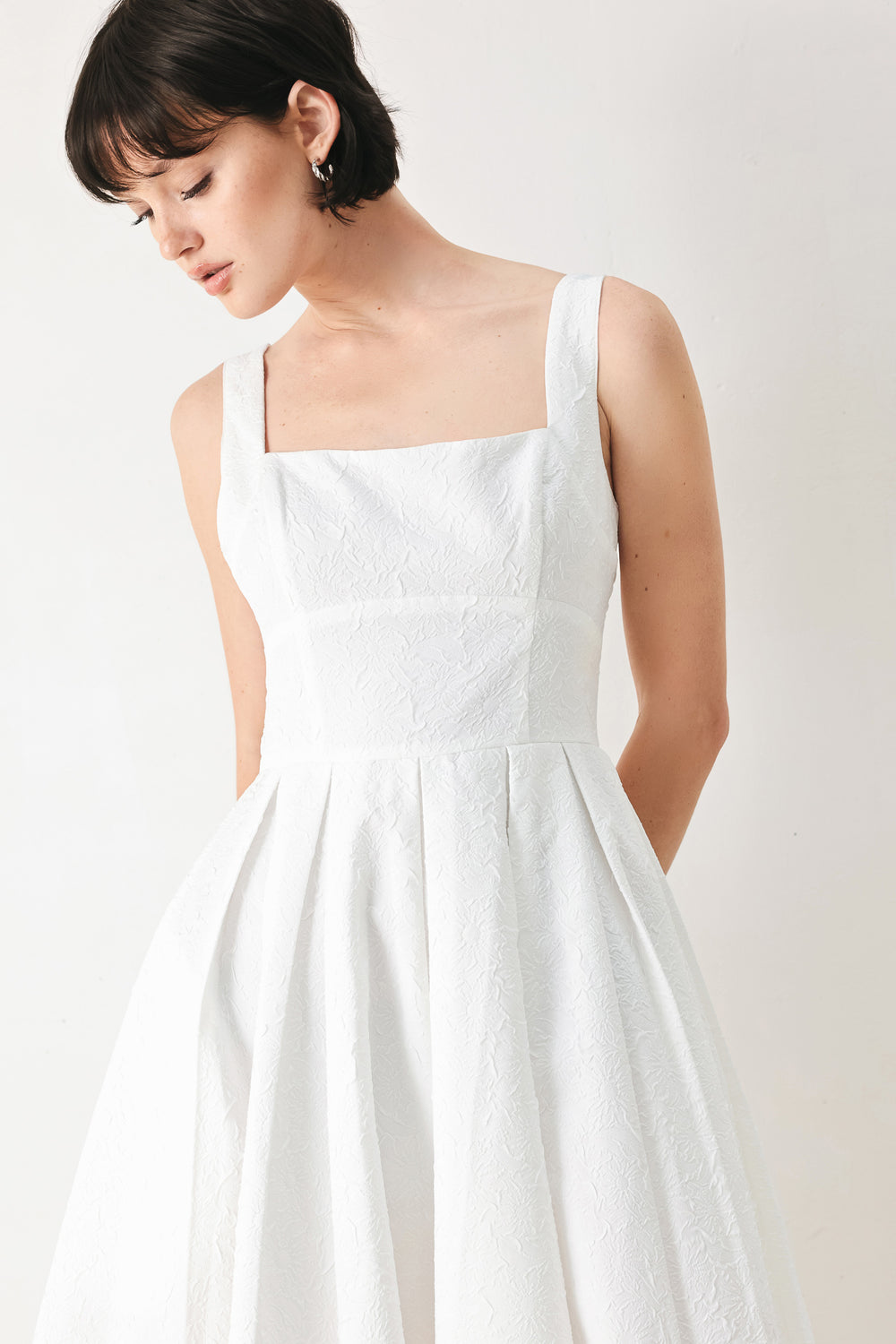 A woman modeling a sleeveless red midi dress with a square neckline, structured bodice, and full pleated skirt | FREEMARKET
