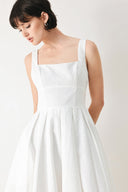 Woman wearing a white midi dress featuring straight neckline, straps, full skirt and back zipper closure | FREEMARKET