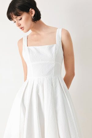 Woman wearing a white midi dress featuring straight neckline, straps, full skirt and back zipper closure | FREEMARKET