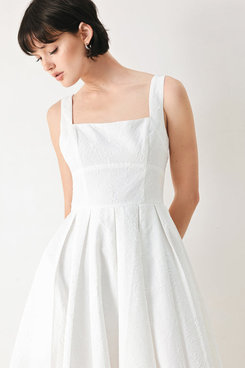 Woman wearing a white midi dress featuring straight neckline, straps, full skirt and back zipper closure | FREEMARKET