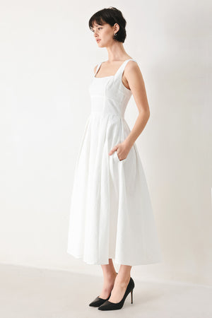 Woman wearing a white midi dress featuring straight neckline, straps, full skirt and back zipper closure | FREEMARKET