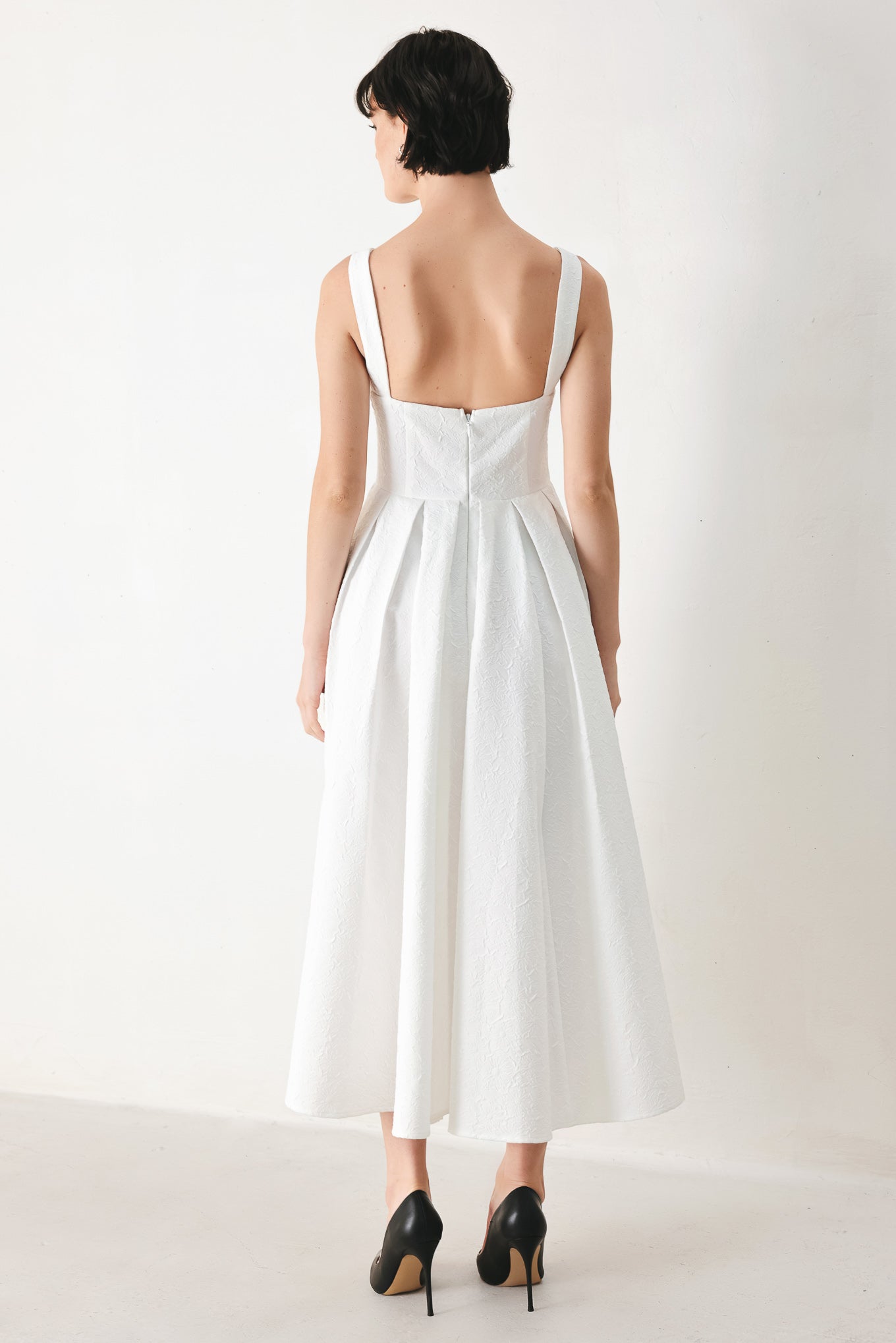 Woman wearing a white midi dress featuring straight neckline, straps, full skirt and back zipper closure | FREEMARKET