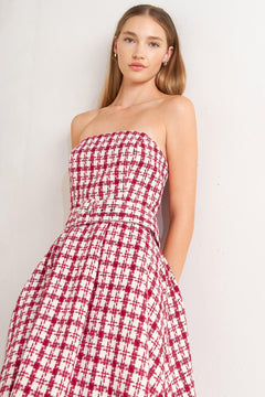 A tweed mini dress featuring strapless, self belt, circle skirt and back zipper closure