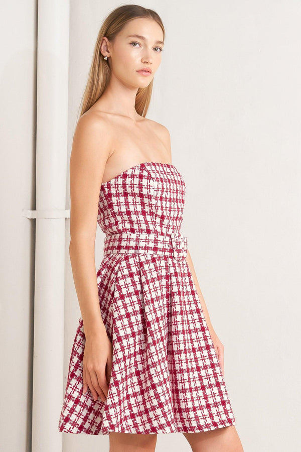A tweed mini dress featuring strapless, self belt, circle skirt and back zipper closure